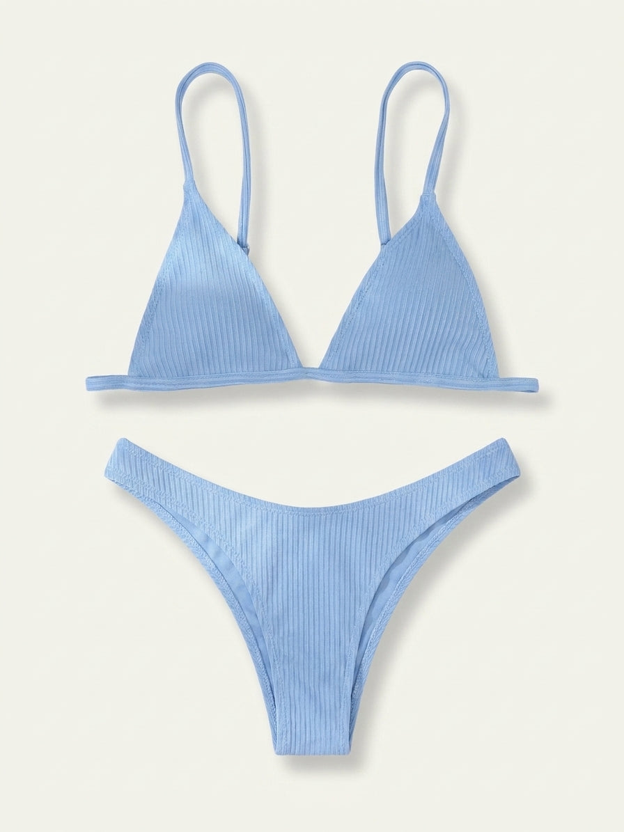 A light blue ribbed two-piece bikini set, featuring a triangle top with thin shoulder straps and matching high-cut bikini bottoms, laid flat against a light cream background.