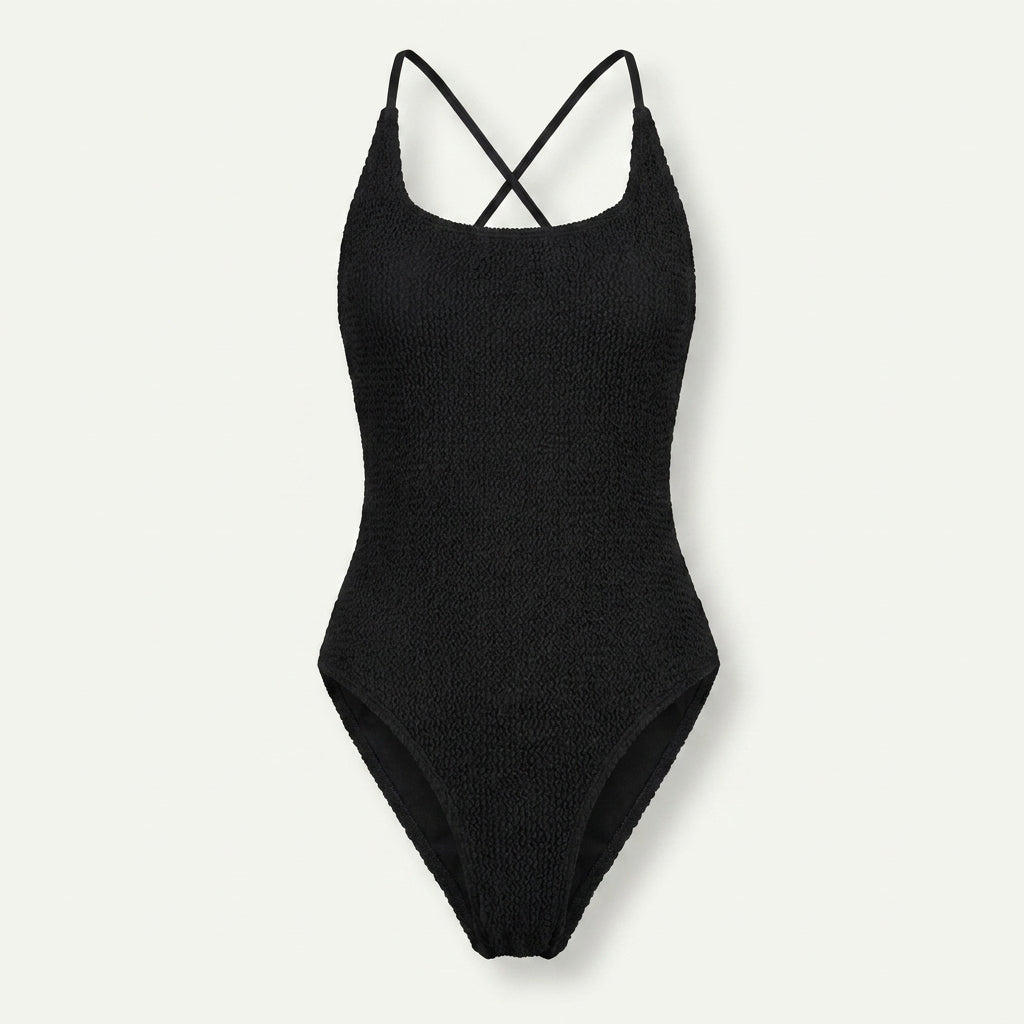 A black ribbed knit one-piece swimsuit with thin crisscross shoulder straps, shown flat against a light off-white background.