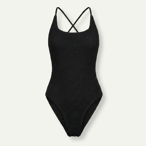 A black ribbed knit one-piece swimsuit with thin crisscross shoulder straps, shown flat against a light off-white background.